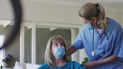 una trabajadora de la salud hablando con una mujer mayor en casa