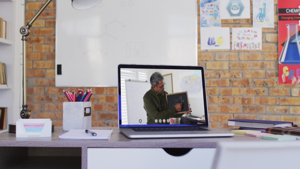 Biracial male teacher displayed on laptop screen during video call