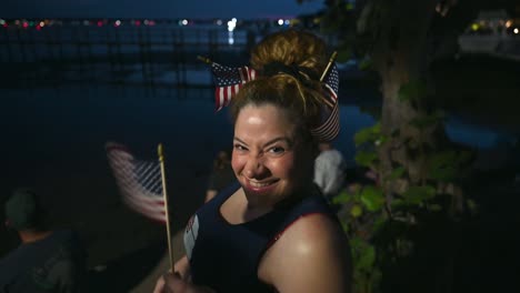 young beautiful woman waving american flag and waiting for fireworks patriotic celebration