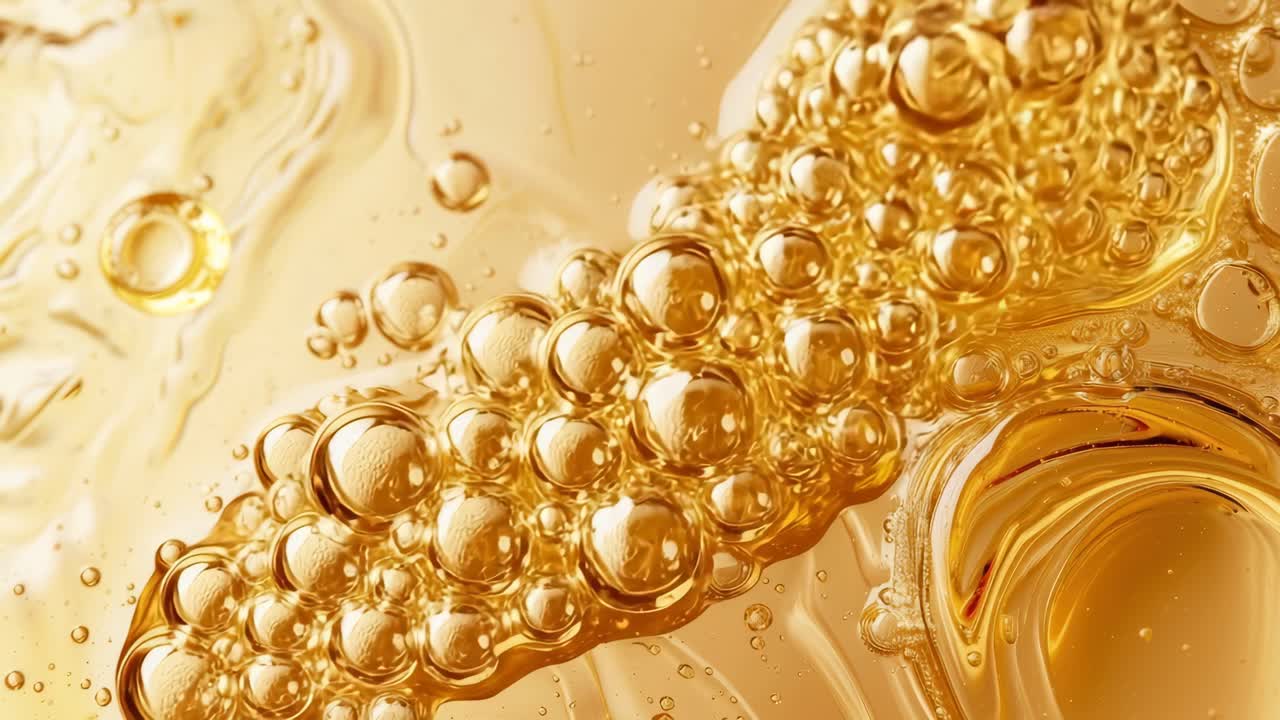 Primo piano di liquido dorato con bolle che creano un ipnotico modello astratto