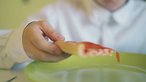 el escolar come pizza con tomates y queso en la mesa.