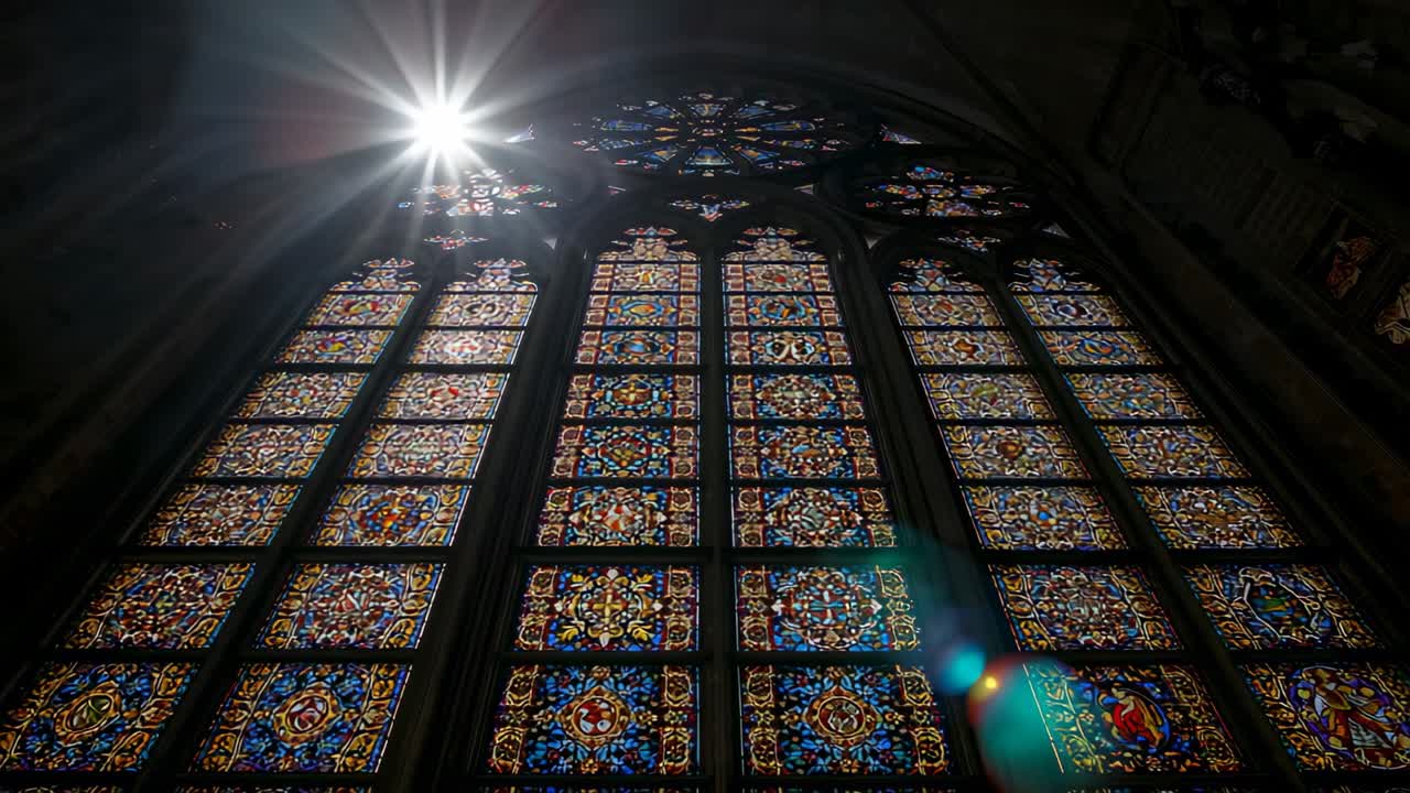 Sunlight appearing illuminating Gothic stained glass window in cathedral nave, with rainbow flares