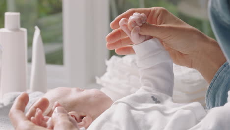 Madre-Feliz-Cuidando-Al-Bebé-En-Casa-Mamá-Amorosa-Cuidando-Al-Niño-Tomándole-La-Mano-Suavemente-Calmando-A-Su-Hijo-Disfrutando-De-La-Maternidad