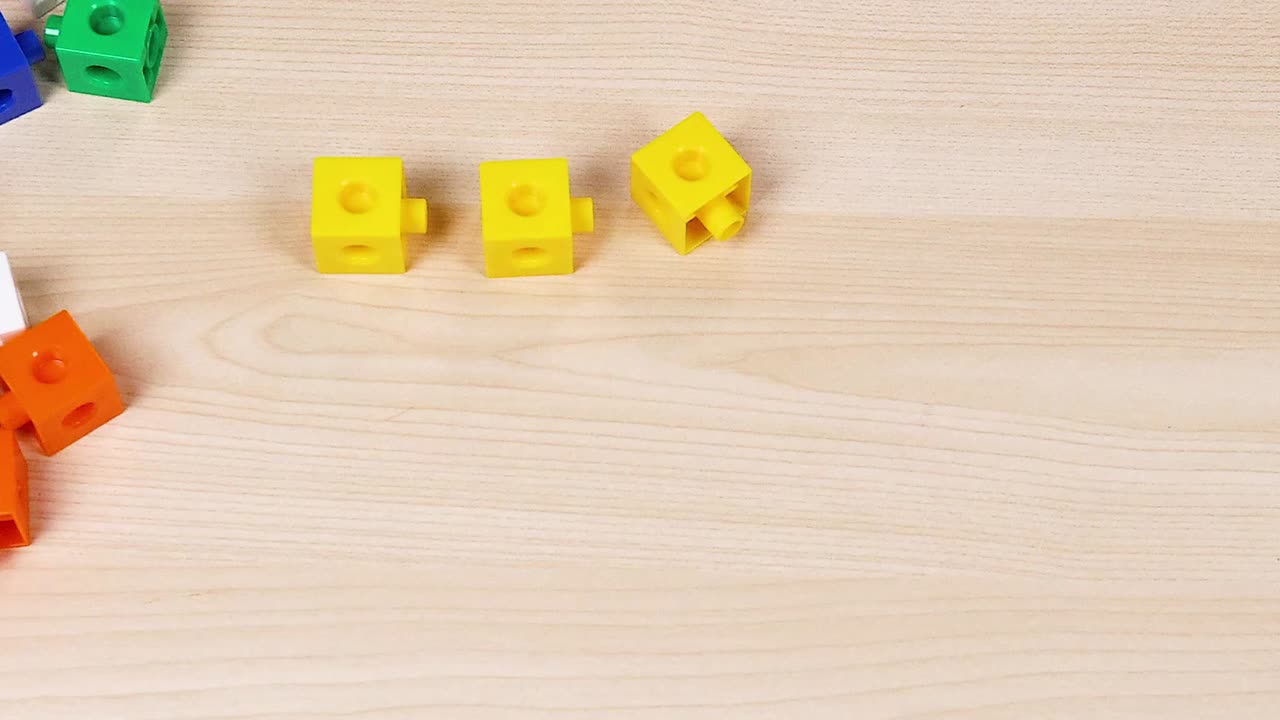 나무 테이블 에 큐브 를 조립 하는 손