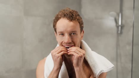 retrato de un hombre guapo rubio insertando clips dentales