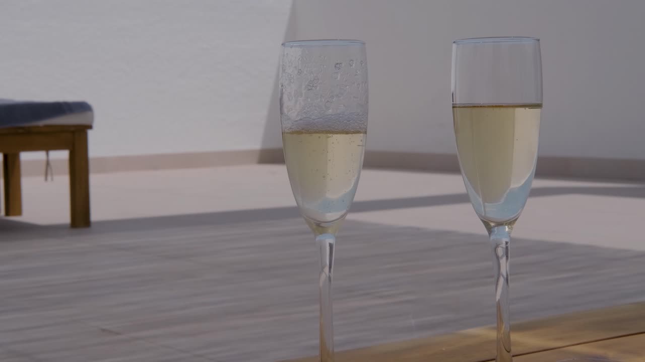Uomo che versa champagne in un flûte su un patio in Costa Blanca, Spagna