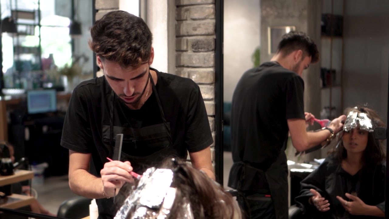 Kapper werkt aan het haar van een vrouw
