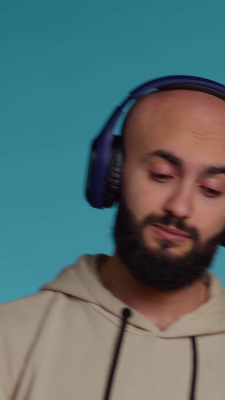Video verticale di persona mediorientale che si diverte ad ascoltare musica con le cuffie