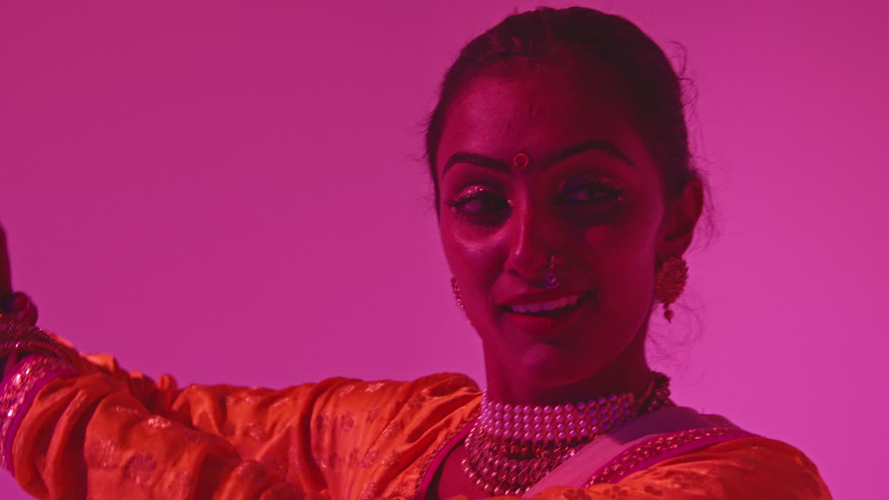 Head And Shoulders Studio Shot Of Female Kathak Dancer Performing Dance Wearing Traditional Indian Dress Against Purple Background 3
