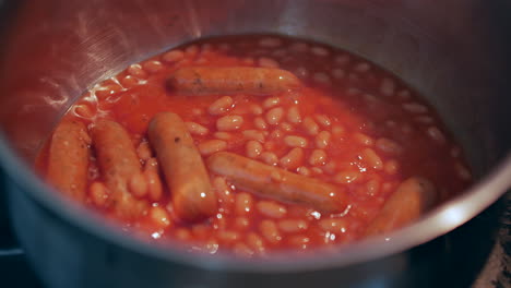 baked beans and sausages cooking in a saucepan