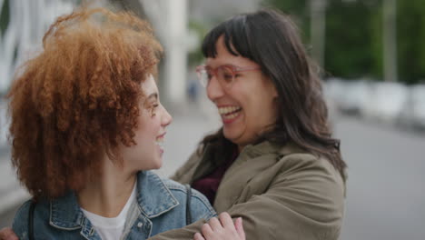 portrait of happy woman suprise kiss hugging friend diverse friends embracing enjoying friendship together in urban city street background slow motion