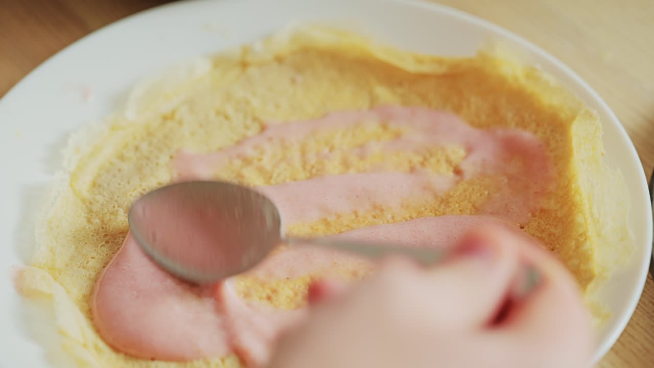 Closeup of man eating sweet crepe with soft strawberry milk cream filling