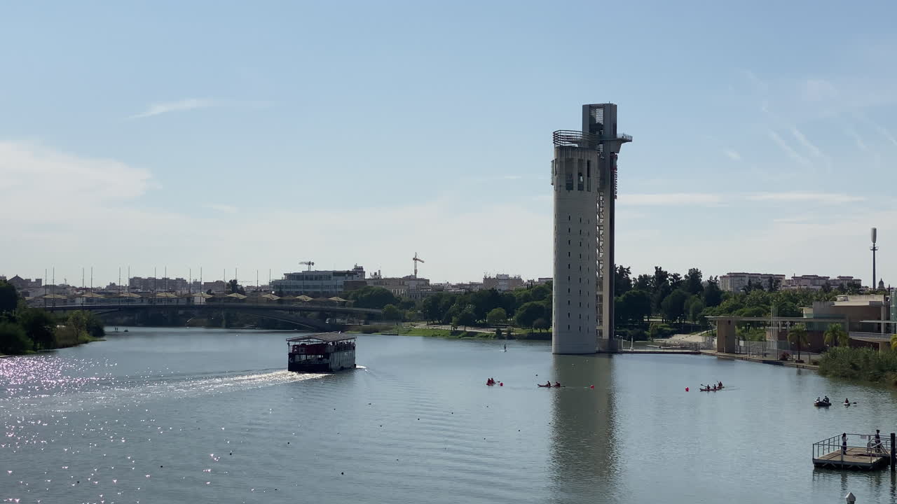 Bred, moderne buebro spænder over en rolig flod under bløde, grå morgenskyer