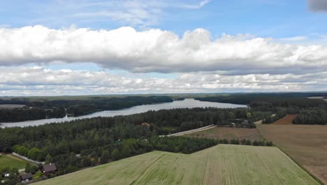 High-altitude-flight-over-Lake-Jezioro-Gwiazdy-and-Borowy-Młyn-village-in-Kaszuby,-Pomeranian-Voivodeship,-Poland