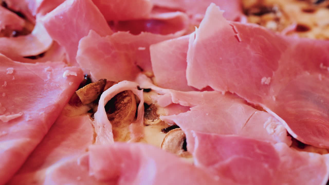Overhead shot of a freshly baked pizza generously topped with thin slices of prosciutto