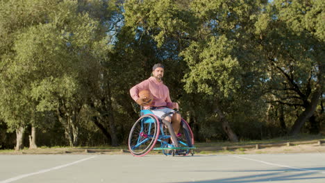 young bearded man in sports wheelchair at basketball court