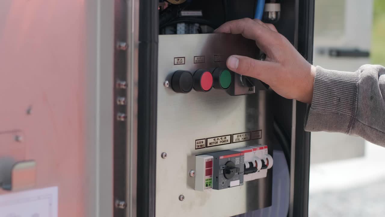 전기 엔지니어가 장비 제어 캐비에서 전기 시스템을 검사합니다.