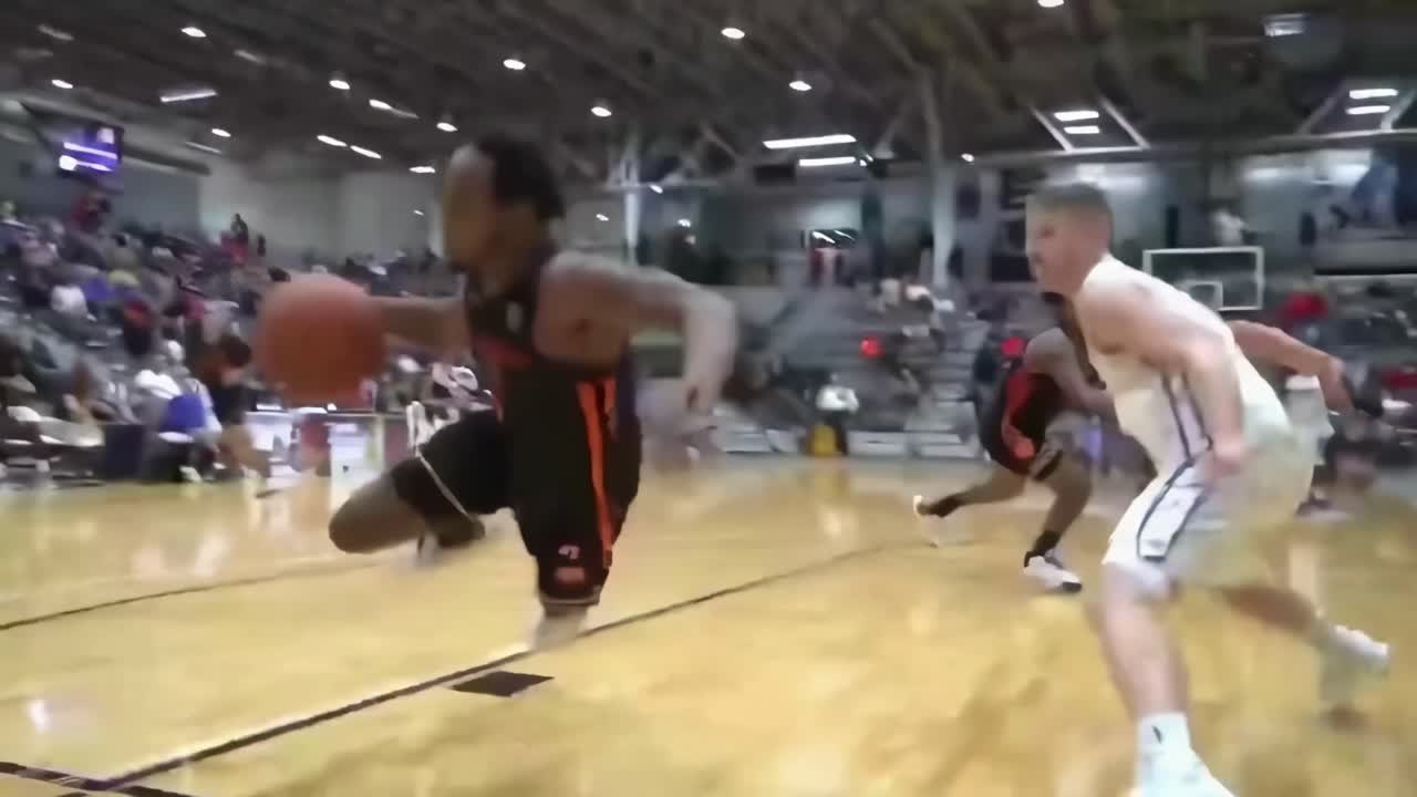 Rekaman video sudut rendah dinamis pertandingan basket, menangkap aksi intens di lapangan.