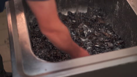 Close-up-top-angle-shot-of-a-chef-washing-morels-in-a-industrial-sink