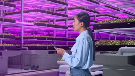 mujer que trabaja en una granja vertical moderna