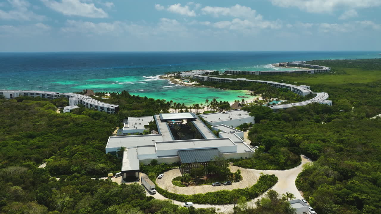Establishing drone shot approaching the Conrad hotel. sunny day in Tulum, Mexico