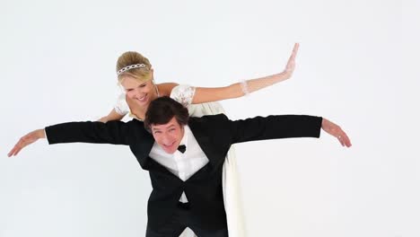 groom carrying pretty new wife on his back