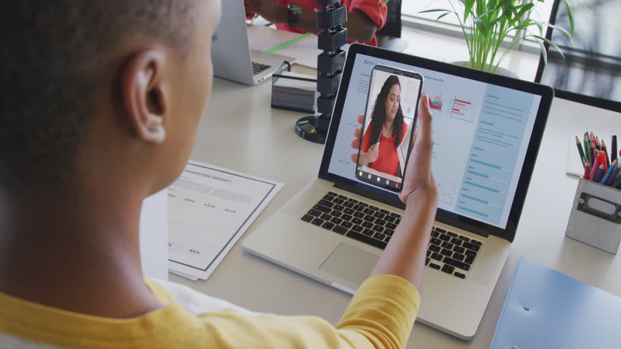 African american businesswoman using smartphone for video call with biracial business colleague