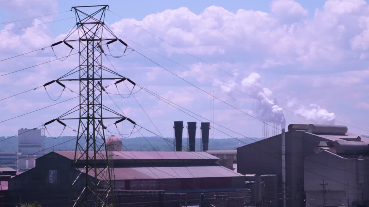 Factories producing pollution in the air on a sunny day with blue skies
