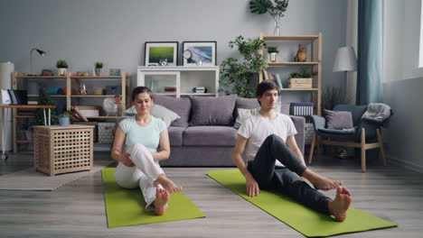 pareja practicando yoga en casa