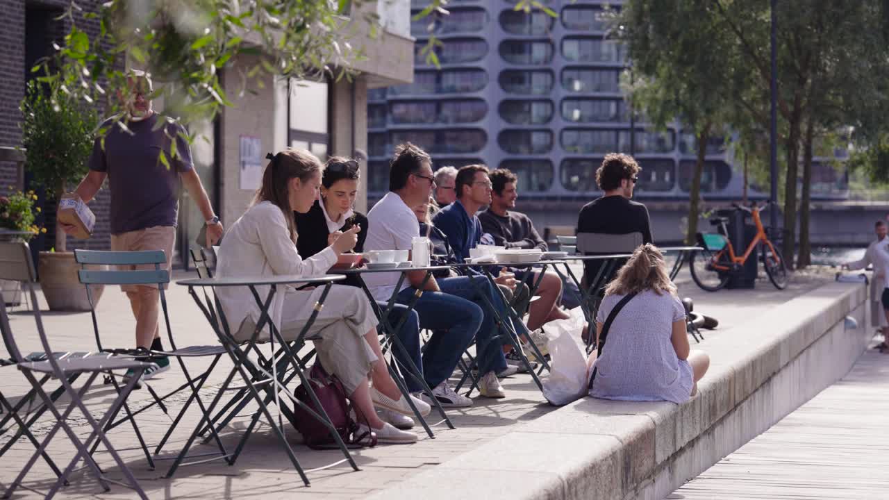 People sit on outdoor restaurant terrace and eat meal, Copenhagen, Denmark