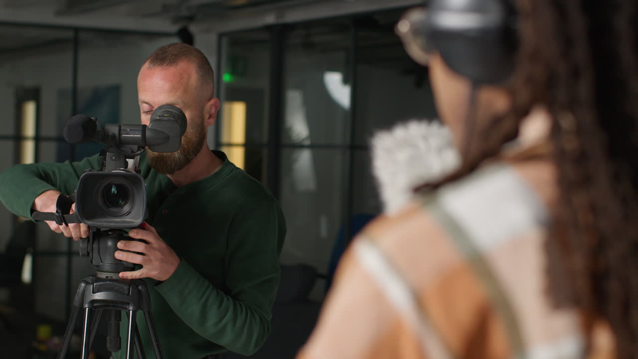 un videógrafo configura su cámara para un rodaje en un estudio