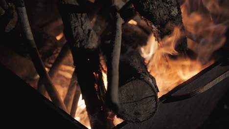 a calm and cozy close-up of logs burning in a slow-motion bonfire outdoors