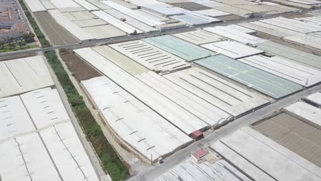 toma aérea inclinada hacia arriba de tierras de cultivo de invernadero en la costa del sur de españa