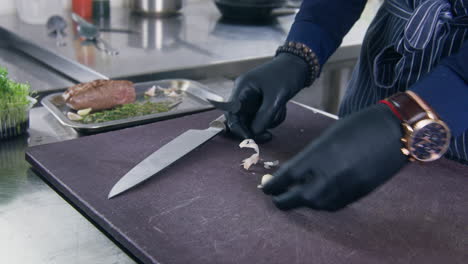 Cook-Cleans-Garlic-By-Knife-on-Cutting-Board