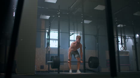 Joven-Haciendo-El-Ejercicio-De-Levantamiento-De-Pesas-Limpio-Y-Tirón-En-El-Gimnasio.-Hombre-Haciendo-Ejercicio-De-Peso-Muerto-En-El-Gimnasio.-El-Joven-Atleta-Levanta-La-Barra-Hasta-El-Pecho.-Levantador-De-Pesas-Masculino-Levantando-Una-Barra-En-Una-Competición