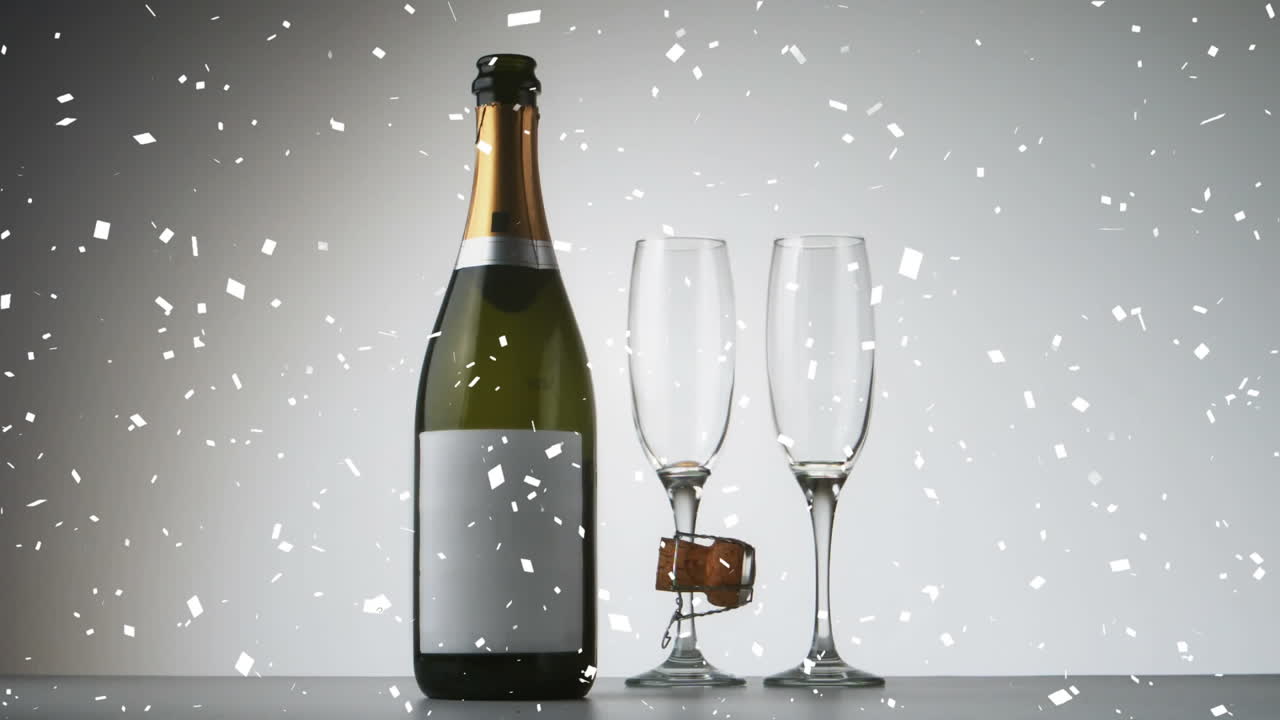 Animazione di coriandoli che cadono sopra una bottiglia e bicchieri di champagne.