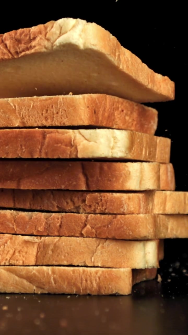 Slow Motion of Fresh Bread Slices Stacking on Black Background
