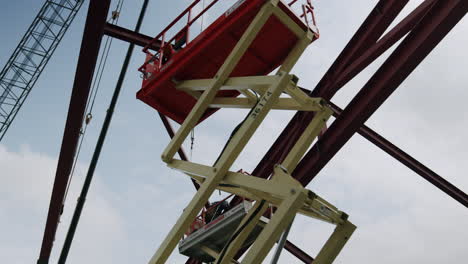 construction of a steel structure with a worker on a scissor lift