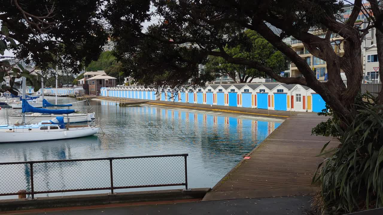 Colorful Boathouses on a Calm Harbor