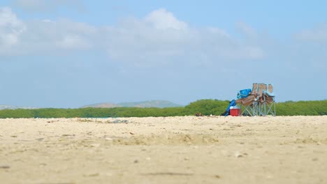 sillas de camping vacías y cosas en la playa de kralendijk, bonaire - plano a nivel del suelo