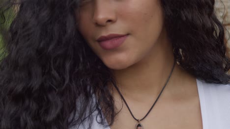 movimiento de cámara ascendente para revelar a una joven de cabello rizado que lleva un collar negro