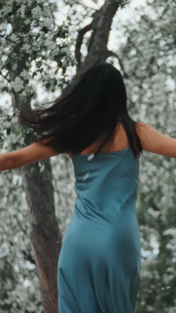 Woman in a blue dress amidst spring flowers