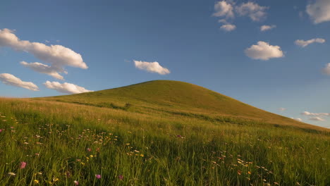 green hill landscape under blue sky with clouds