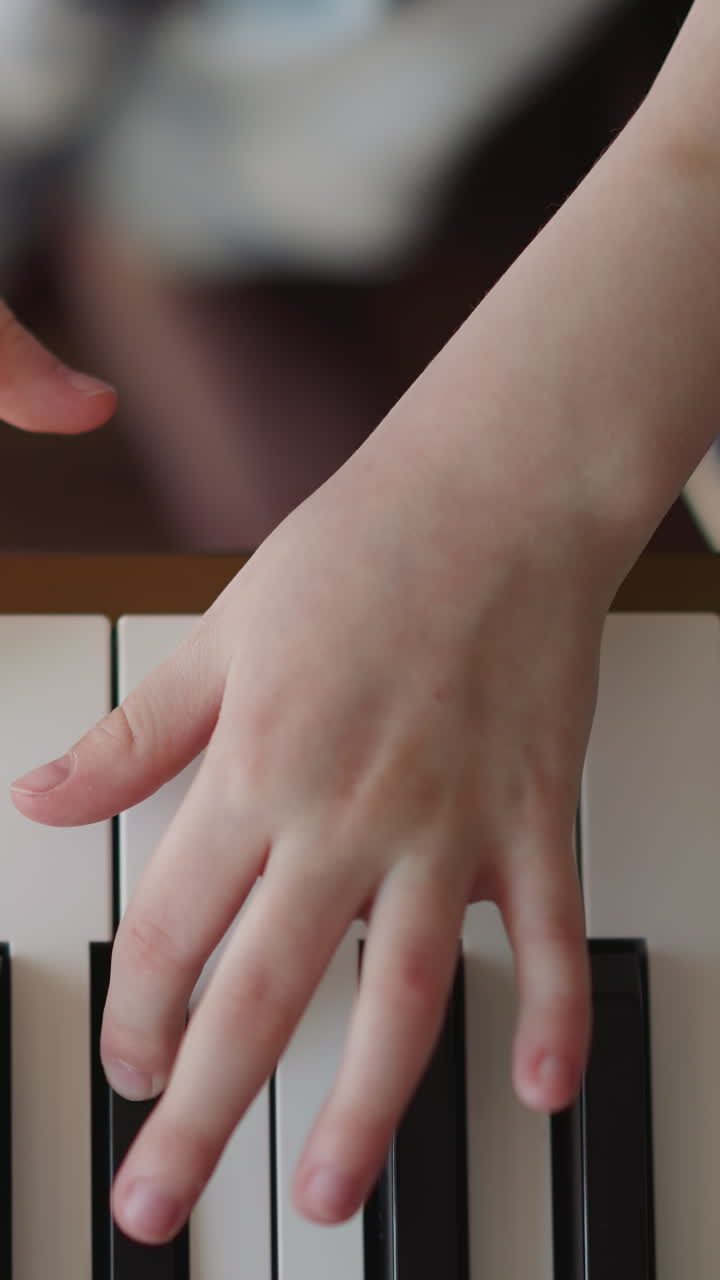 Child musician plays piano. Girl hands press keys in connected manner. Improving skills of playing musical instrument upper view on blurred background