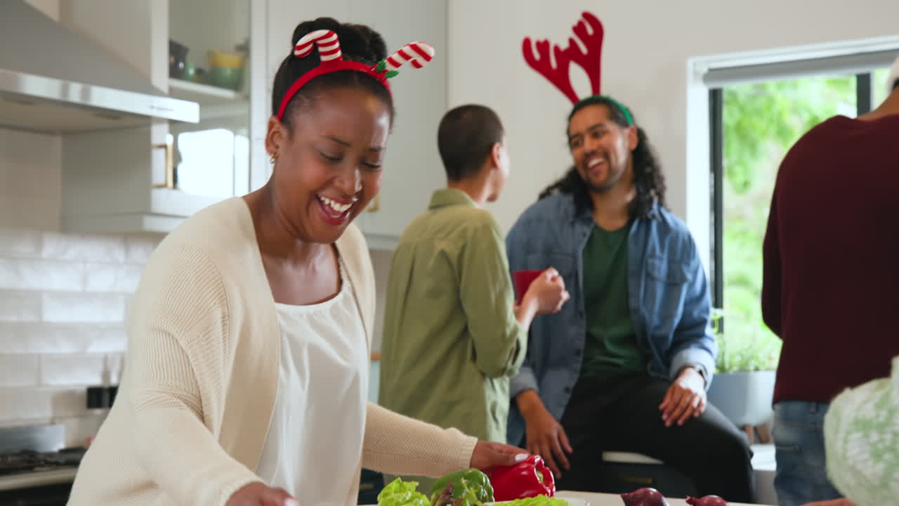 At christmas, preparing festive meal, diverse friends wearing holiday accessories, smiling together