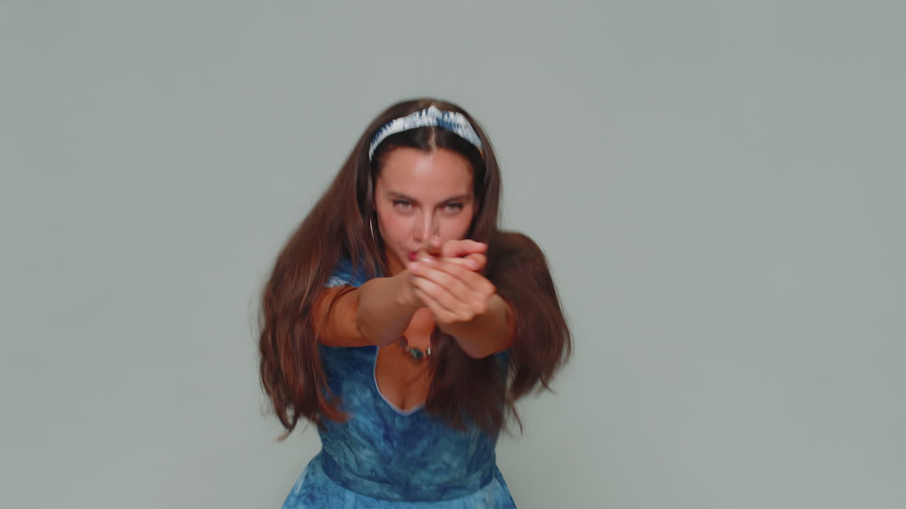 una chica bastante segura apuntando con el dedo un gesto de arma, tomando una decisión, disparando matando