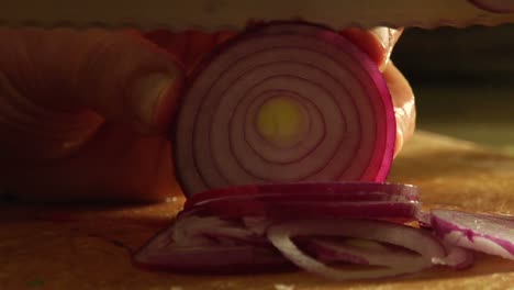 a man slices a red onion on a cutting board