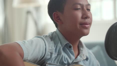 Boy Singing and Playing Acoustic Guitar