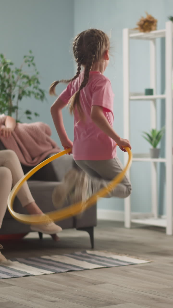 young woman, mother with children playing in room, throwing toys, twisting hoop, weekend with children, family