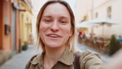 a young woman takes a selfie in a european city